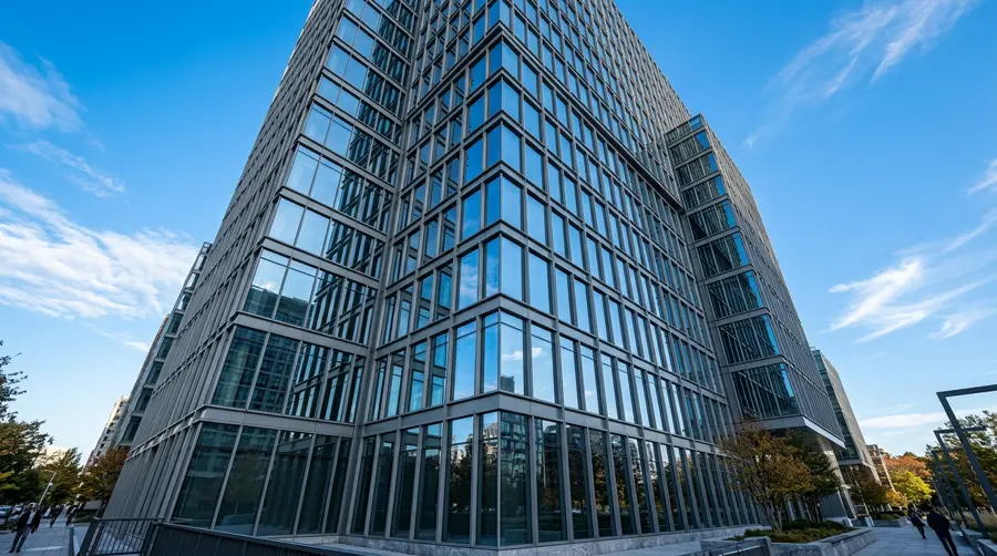 Glass office facade framed by aluminum curtain wall mullions against a blue sky
